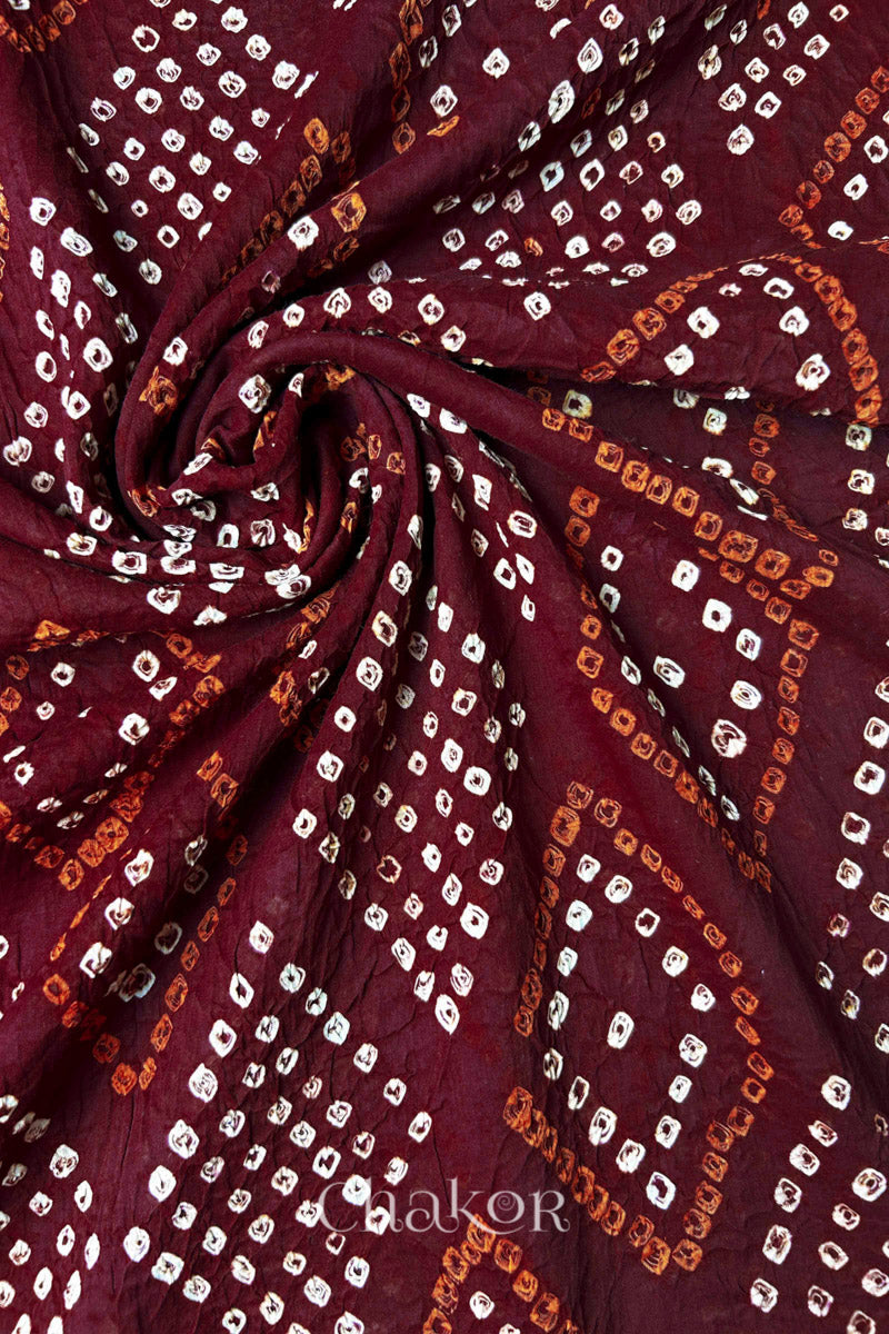 Fabric swirl close-up of Maroon Bandhani Mul Cotton Dupatta highlighting dense tie-dye work  by Chakor.
