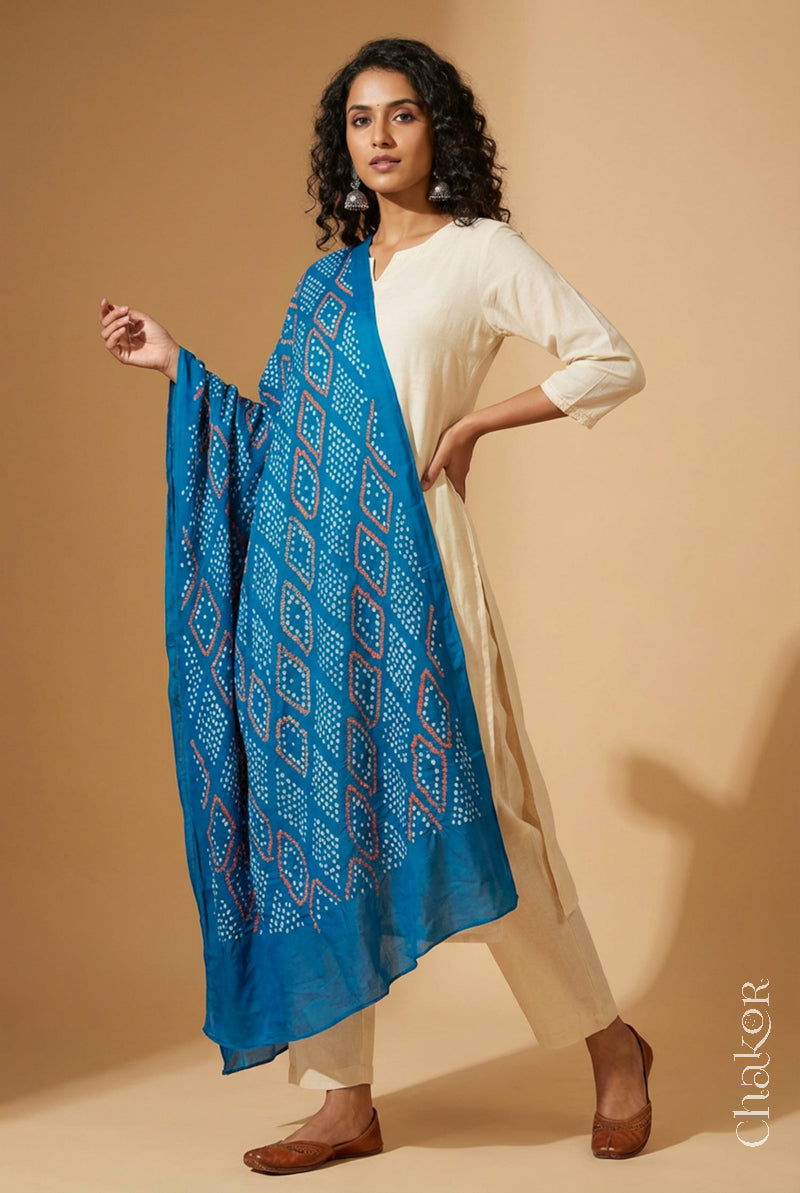 Model wearing turquoise Bandhani mul cotton dupatta with tie-dye dot pattern paired with a white kurta.