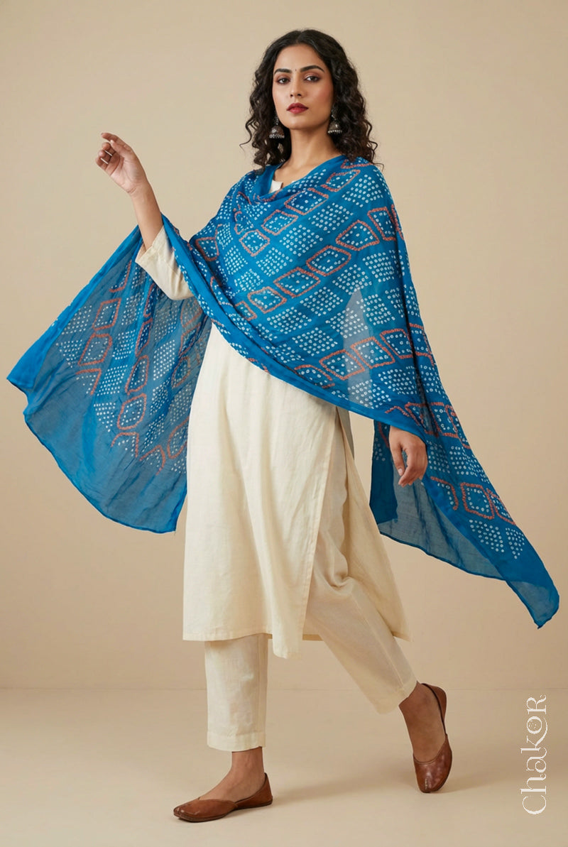 Model wearing turquoise Bandhani mul cotton dupatta with tie-dye dot pattern paired with a white kurta.
