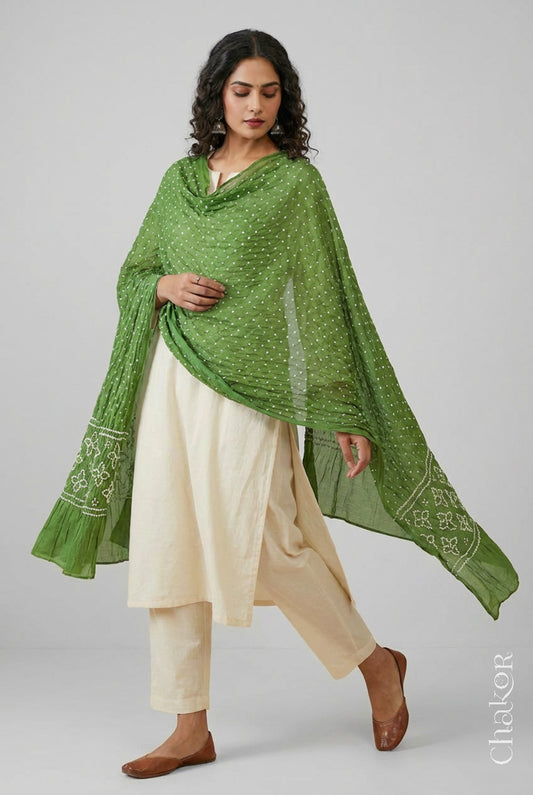Model wearing olive green Bandhani mul cotton dupatta with tie-dye dot pattern paired with a white kurta.