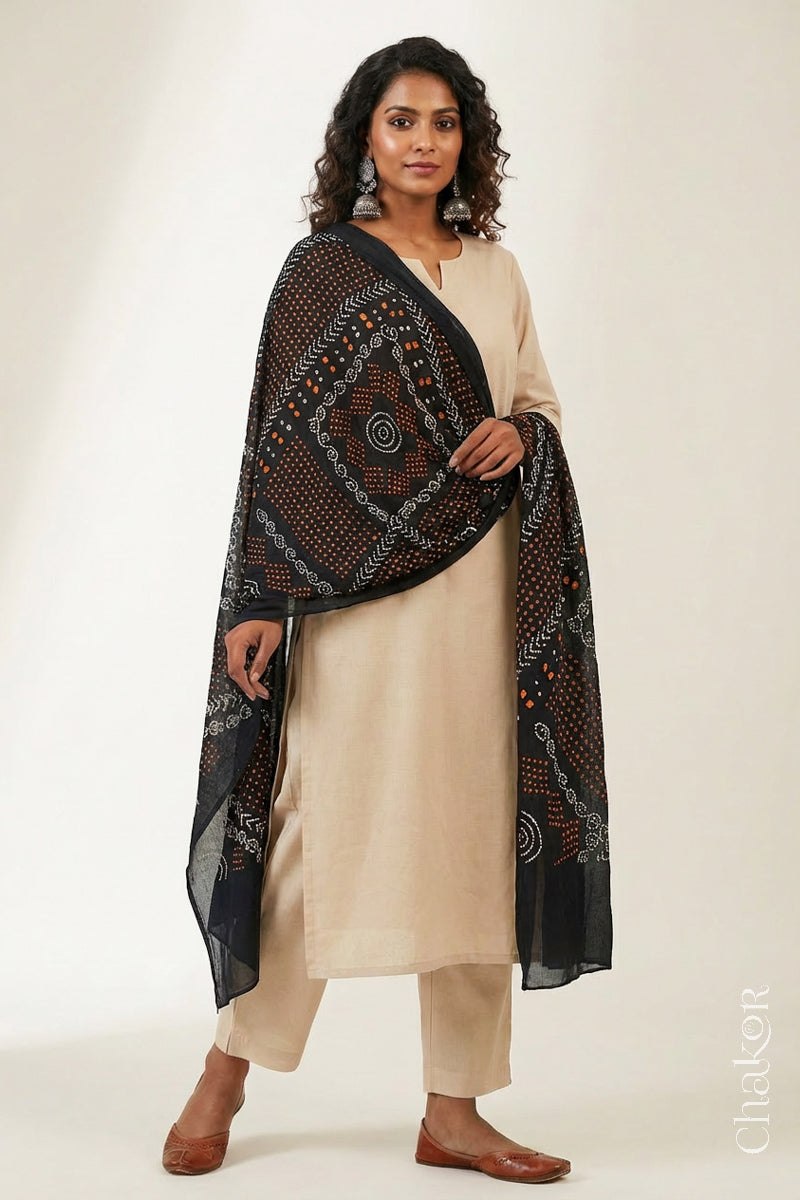 Model wearing black Bandhani mul cotton dupatta with tie-dye dot pattern draped over a beige kurta.