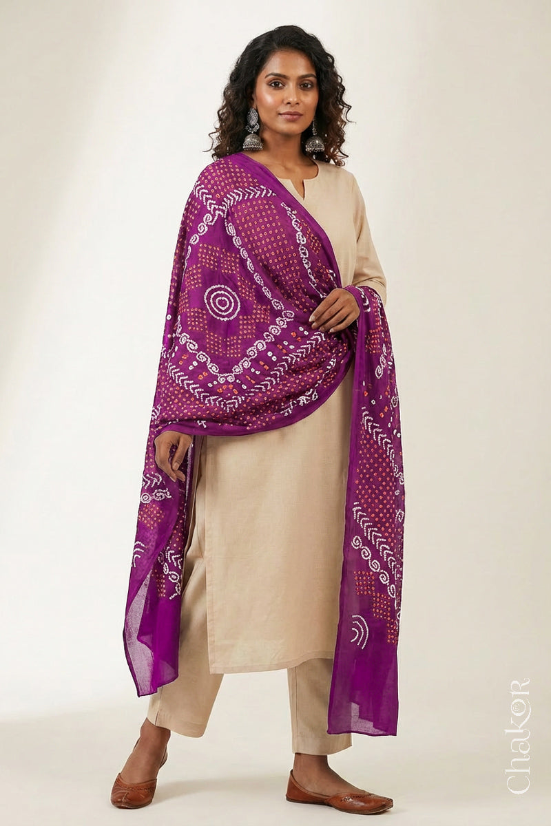 Model wearing magenta Bandhani mul cotton dupatta with tie-dye dot pattern draped over a beige kurta.