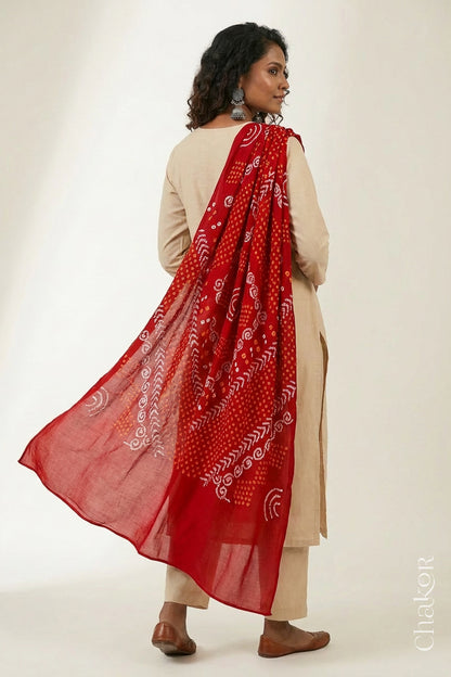 Model wearing red Bandhani mul cotton dupatta with tie-dye dot pattern draped over a beige kurta.