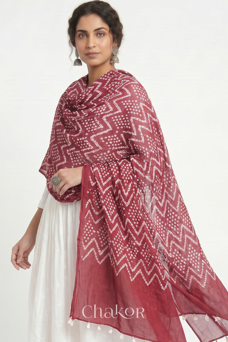 Hand tied Dusty red Kutch Bandhani dupatta in pure mercerised mulmul cotton worn by model.
