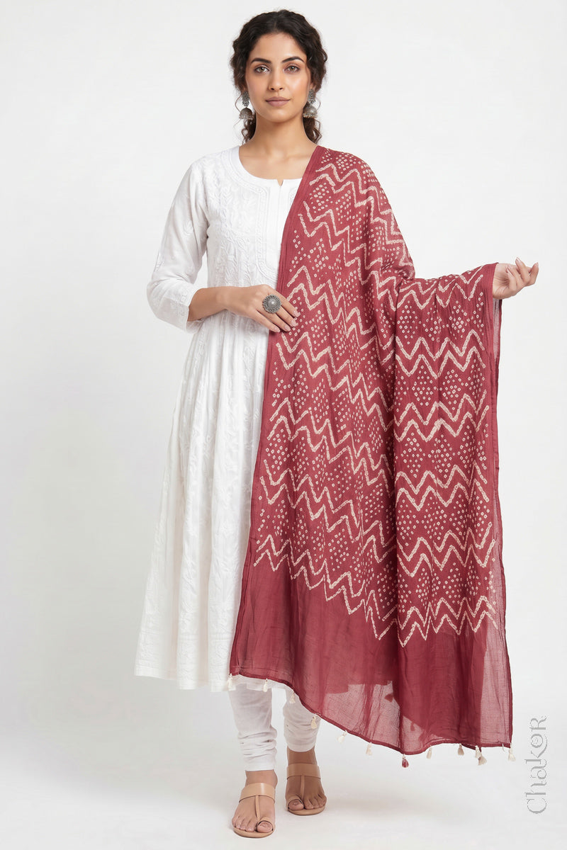 Dusty red Kutch Bandhani dupatta in lightweight mercerised mulmul cotton with flowing drape.
