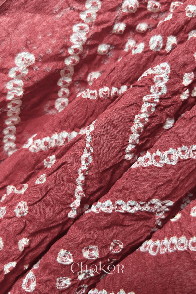 Close up of Traditional hand tied Bandhani pattern on Dusty red mulmul cotton dupatta.
