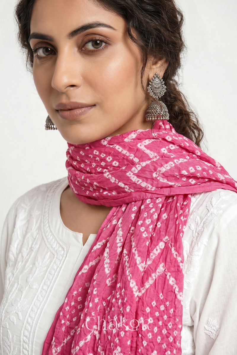 Pink Kutch Bandhani mulmul dupatta wrapped around woman's neck.
