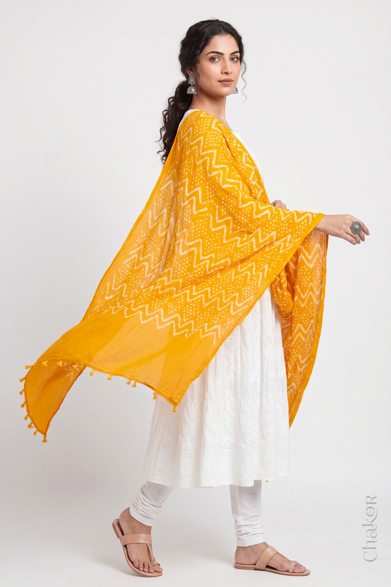 Yellow Kutch Bandhani dupatta in mercerised mulmul cotton shown in side drape styling.
