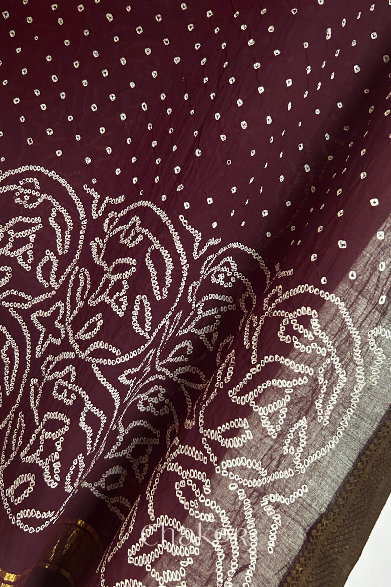 Close-up of maroon Mangalgiri cotton fabric showing its handloom weave and opacity.
