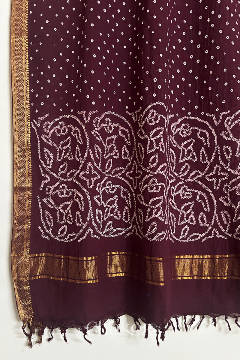 Maroon Bandhani Mangalgiri cotton dupatta, showing the draped of patterned pallu, golden zari detailing and tassels.

