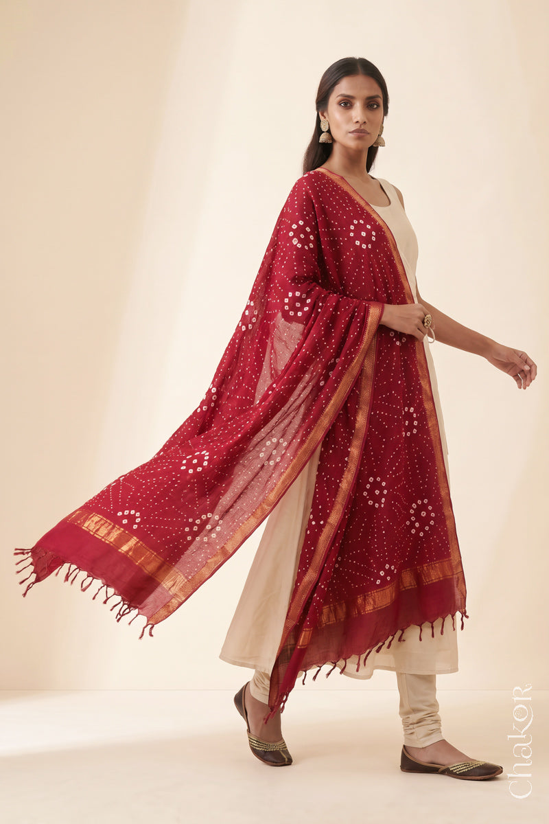Red Bandhani handloom Mangalgiri cotton dupatta worn by a woman, shown in motion.
