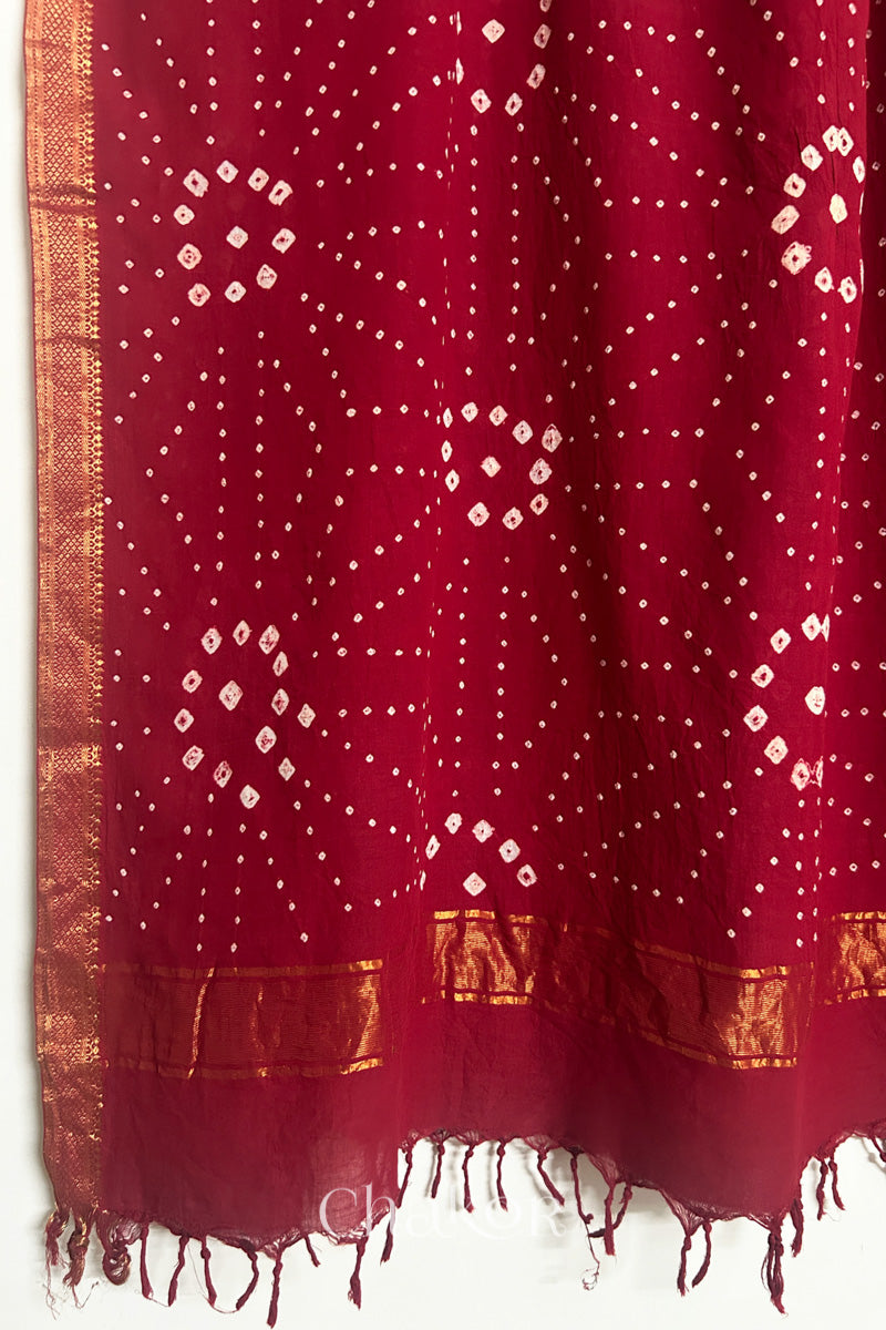 Red Bandhani Mangalgiri cotton dupatta, showing the draped of patterned pallu, golden zari detailing and tassels.
