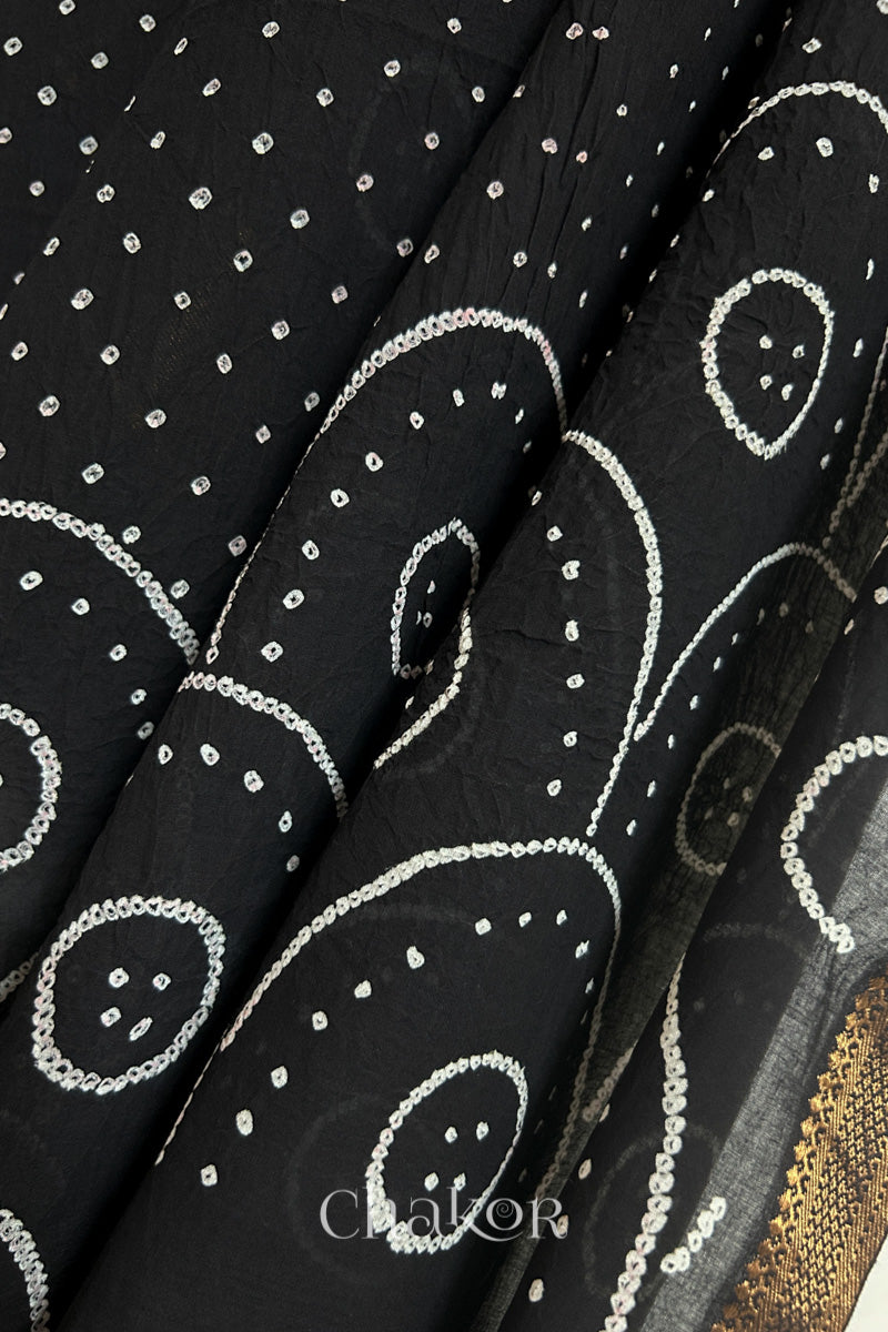 Close-up of Black Mangalgiri cotton fabric showing its handloom weave and opacity.
