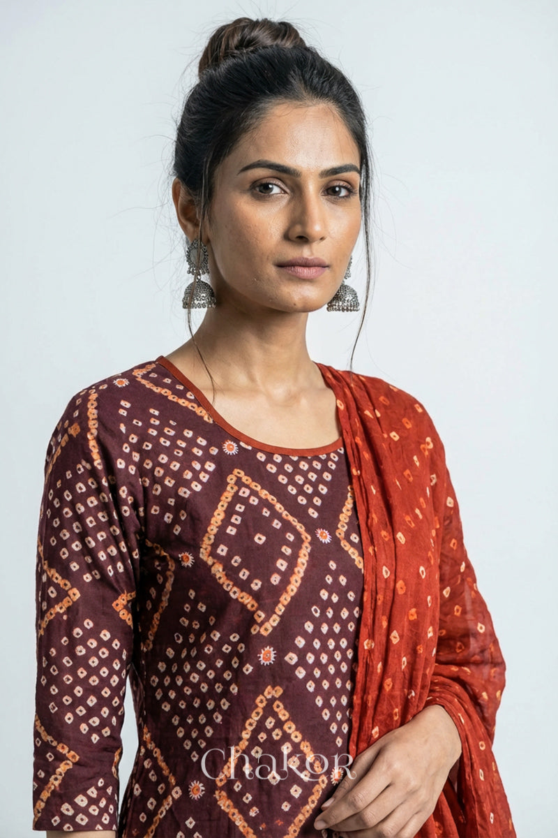 Model wearing Handcrafted Brown Bandhani Cotton Kurta and Rust Pant Set with Dupatta with traditional design and hand embroidery.
