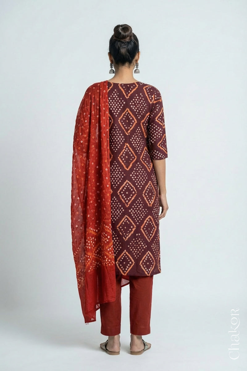 Model wearing Handcrafted Brown Bandhani Cotton Kurta and Rust Pant Set with Dupatta with traditional design and hand embroidery.