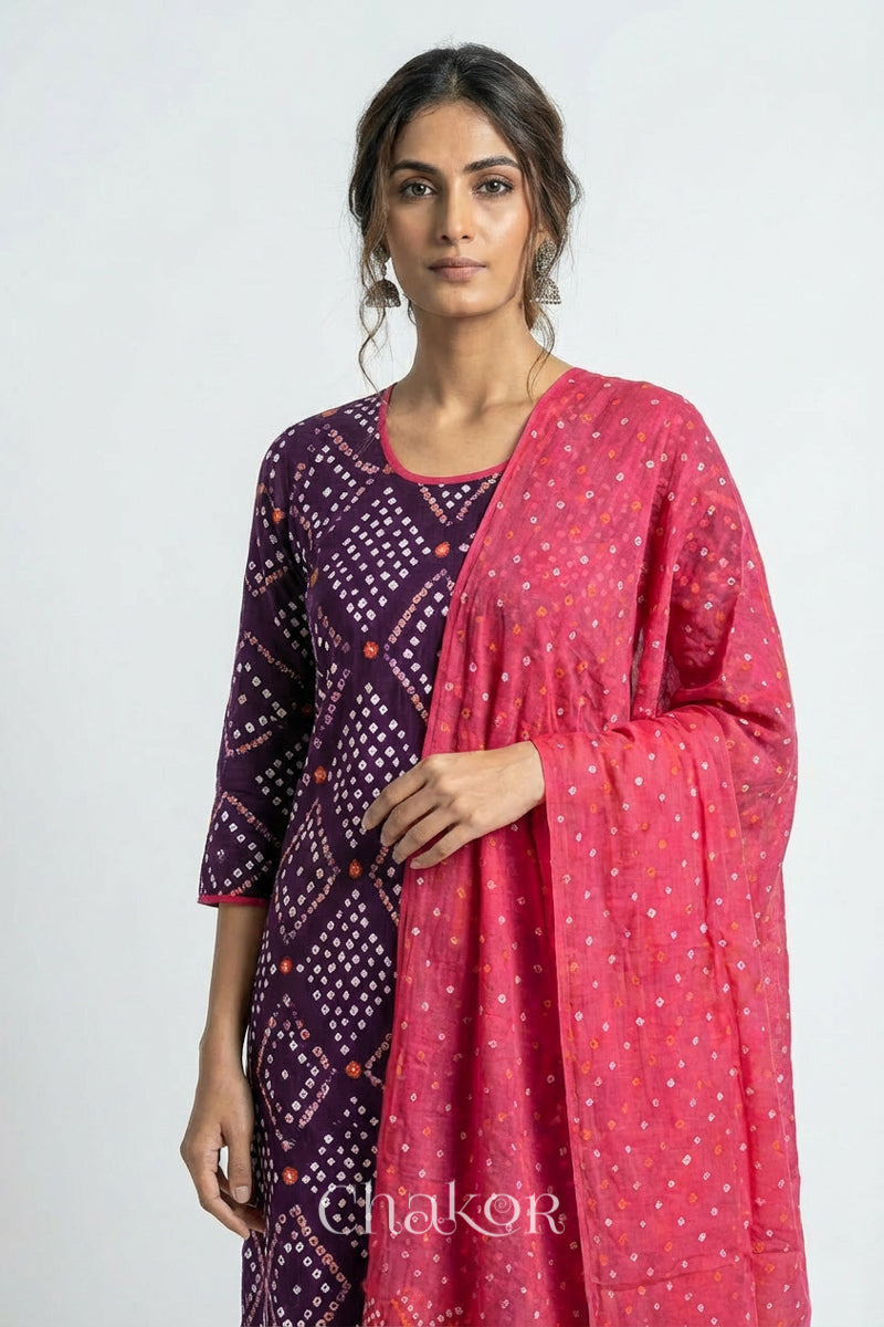 Model wearing Handcrafted Purple Bandhani Cotton Kurta and Pink Pant Set with Dupatta with traditional design and hand embroidery.