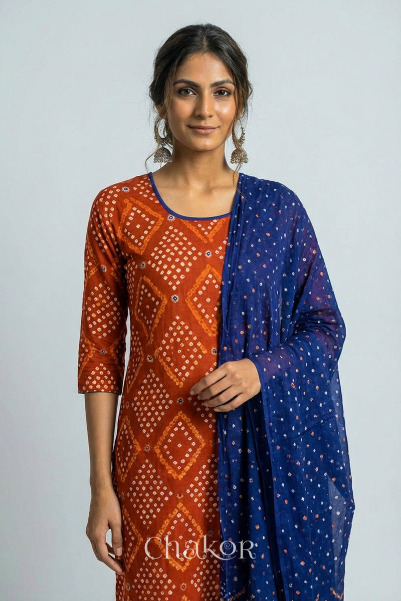 Model wearing Handcrafted Rust Bandhani Cotton Kurta and Blue Pant Set with Dupatta with traditional design and hand embroidery.