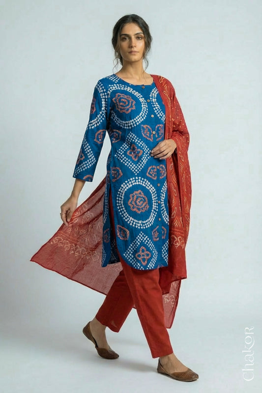 Woman wearing a handcrafted Indigo blue and rust Kurta Set and a matching dupatta with traditional bandhani tie-dye patterns.
