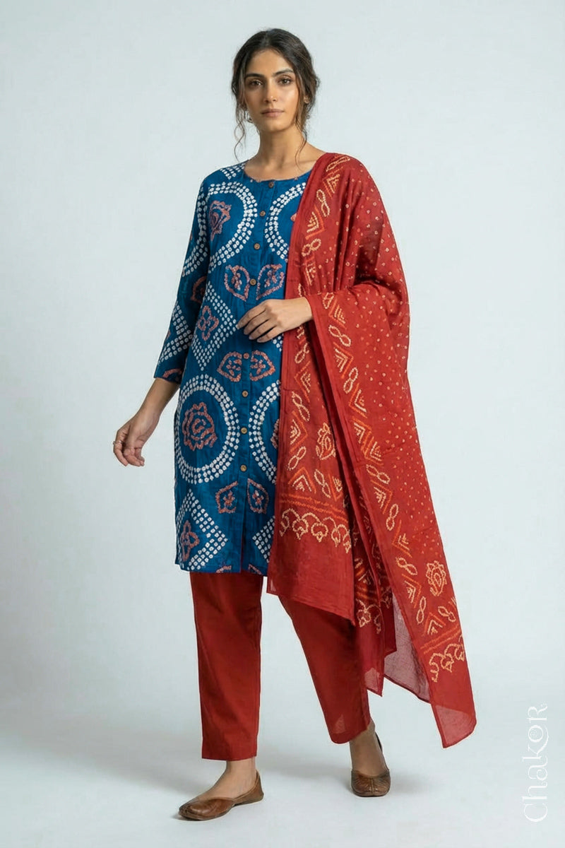 Woman wearing a handcrafted Indigo blue and rust Kurta Set and a matching dupatta with traditional bandhani tie-dye patterns.