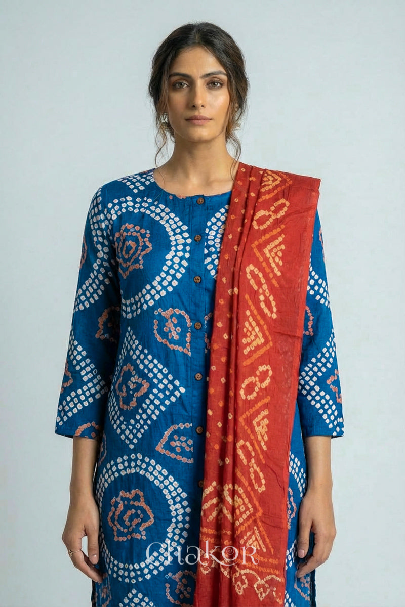 Woman wearing a handcrafted Indigo blue and rust Kurta Set and a matching dupatta with traditional bandhani tie-dye patterns.