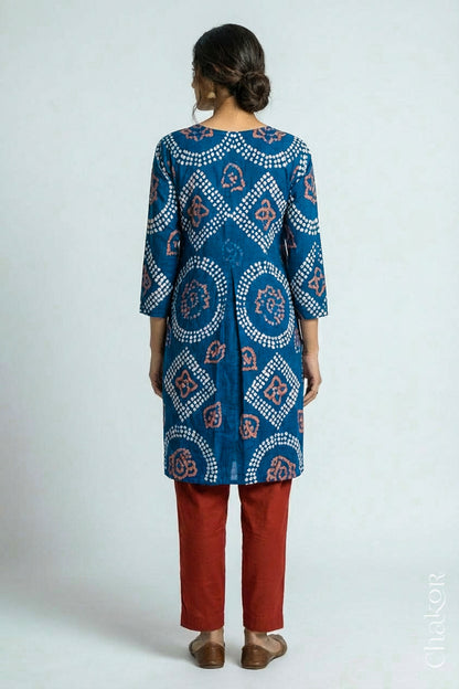 Woman wearing a handcrafted Indigo blue and rust Kurta Set and a matching dupatta with traditional bandhani tie-dye patterns.