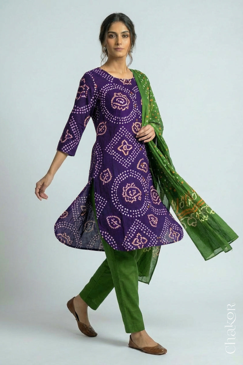 Woman wearing a handcrafted Purple and green Kurta Set and a matching dupatta with traditional bandhani tie-dye patterns.