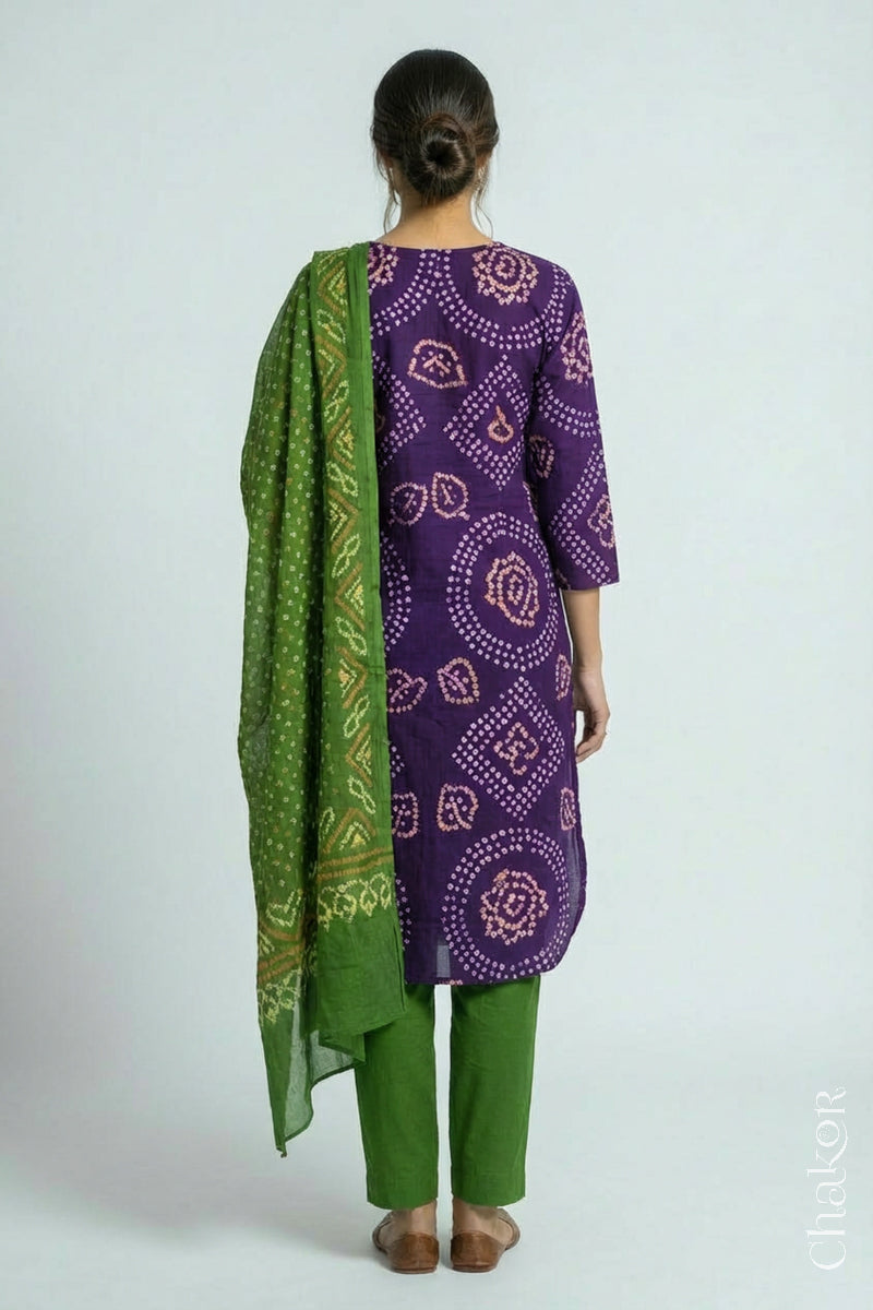 Woman wearing a handcrafted Purple and green Kurta Set and a matching dupatta with traditional bandhani tie-dye patterns.