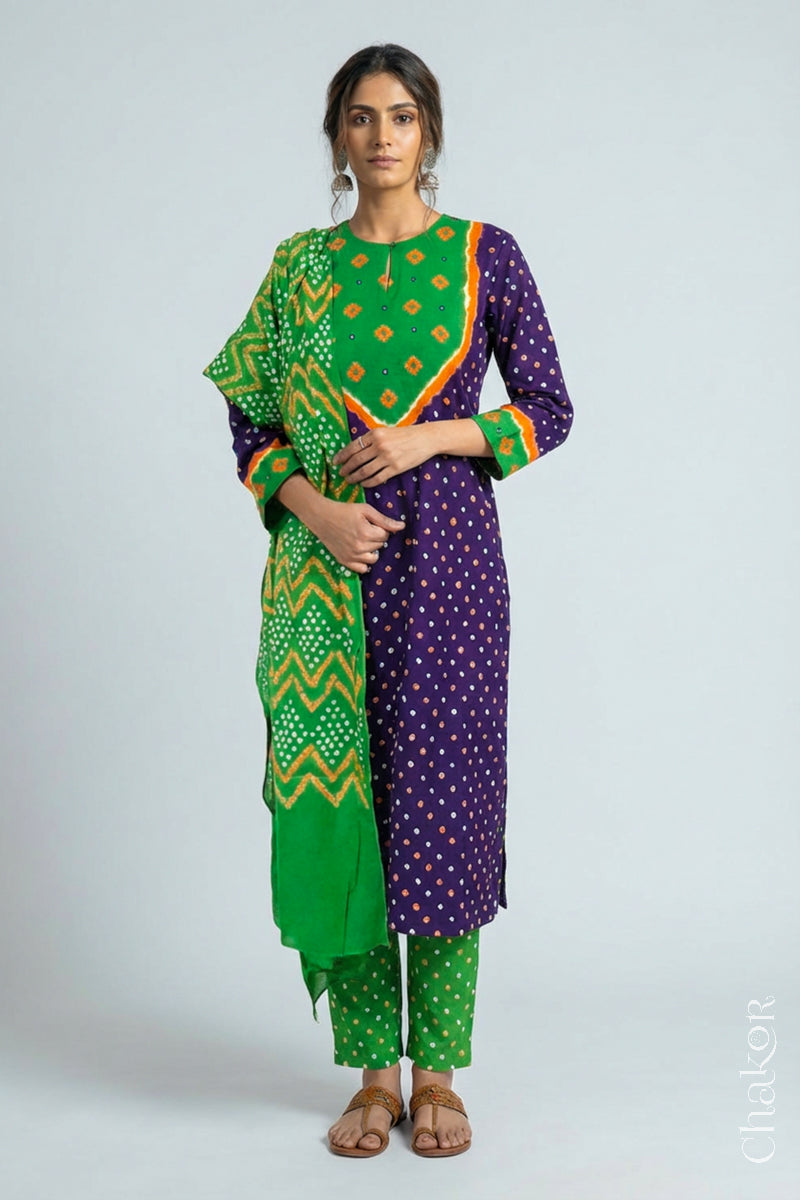 Model wearing Handcrafted Purple Mehendi Bandhani Cotton Kurta Set with kutch hand embroidery and paired with laher pattern Dupatta. 