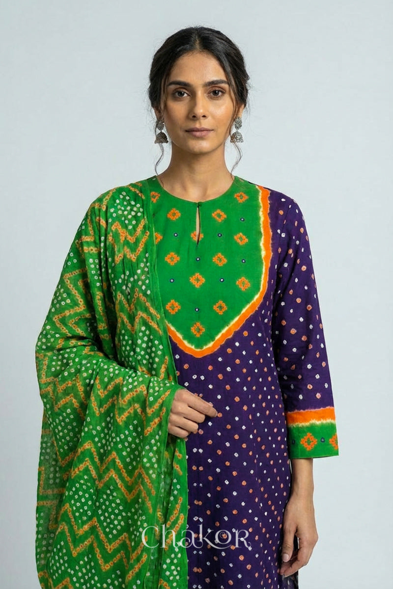Model wearing Handcrafted Purple Mehendi Bandhani Cotton Kurta Set with kutch hand embroidery and paired with laher pattern Dupatta. 
