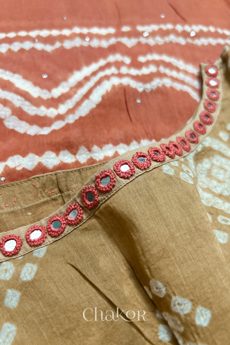 Mirror work neckline detail on mulmul cotton bandhani kaftan in beige and rust, handcrafted in Kutch.
