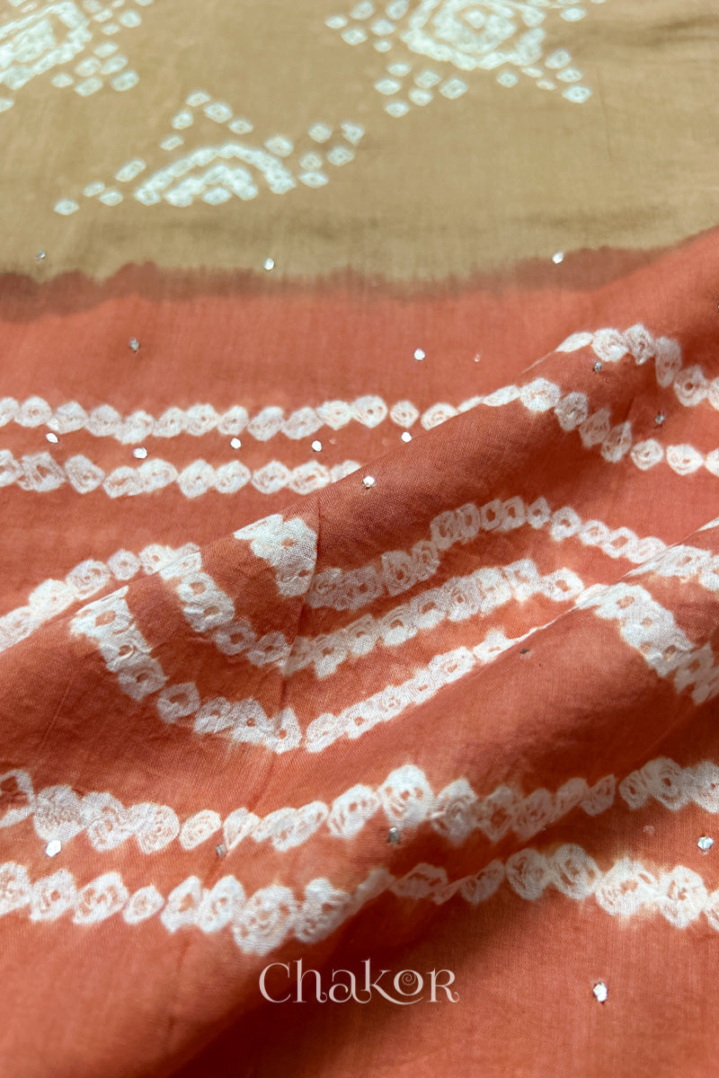 Mulmul cotton bandhani fabric with mukaish embroidery detail in beige and rust.
