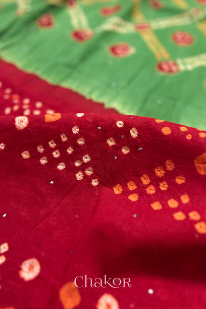 Mulmul cotton bandhani fabric with mukaish embroidery detail in green and red.