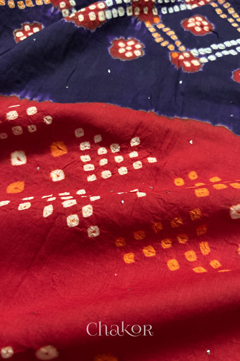 Mulmul cotton bandhani fabric with mukaish embroidery detail in purple and red.

