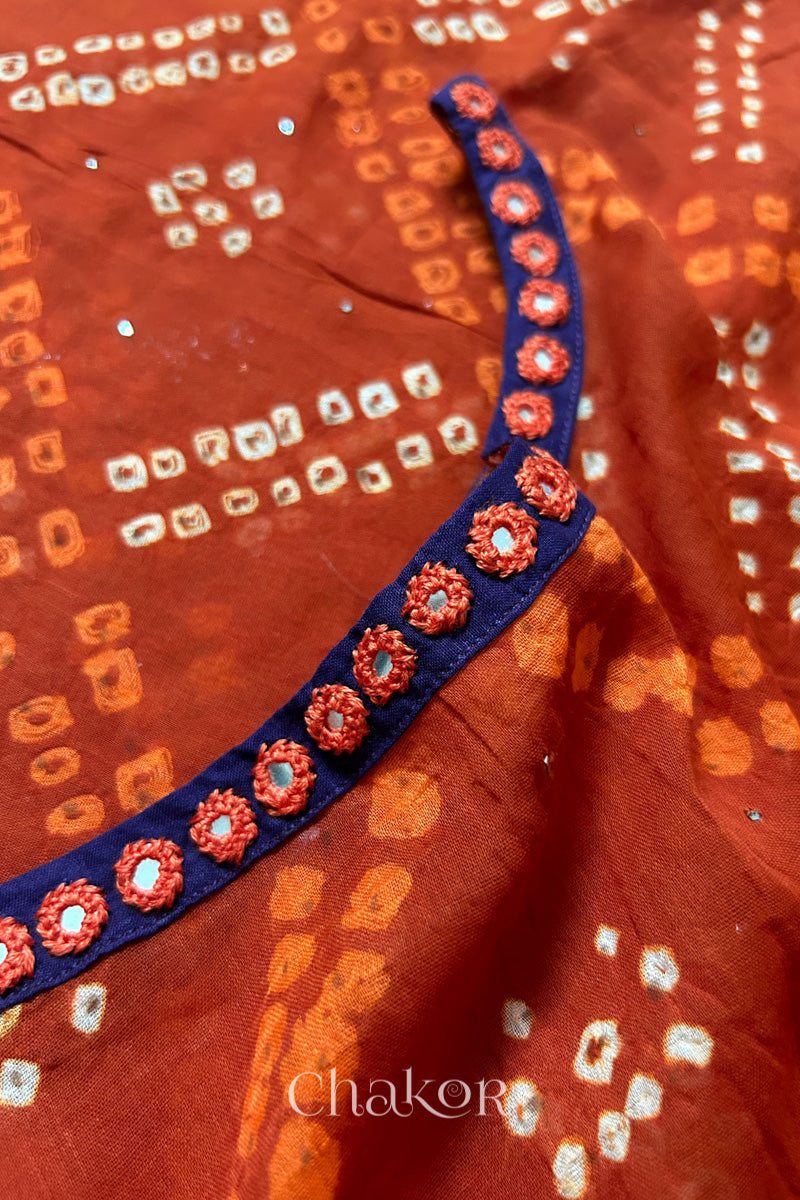 Mirror work neckline detail on mulmul cotton bandhani kaftan in rusty orange, handcrafted in Kutch.
