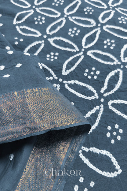 Close-up of grey sarees featuring rai bandhani and zari weaving showcasing beautiful craftsmanship.

