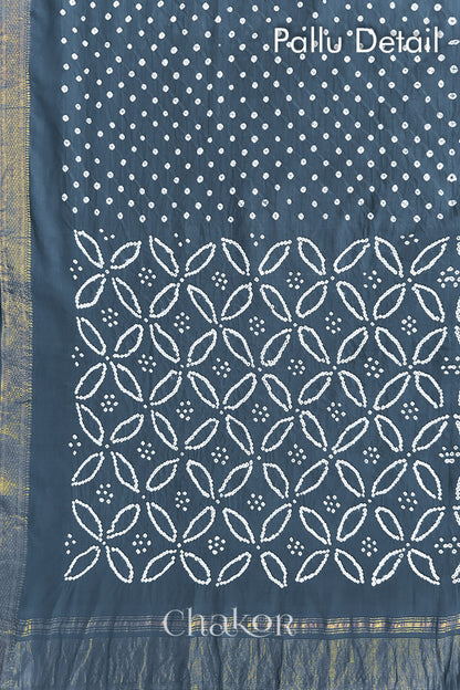 Pallu detail of grey bandhani saree with woven golden zari border and pallu.
