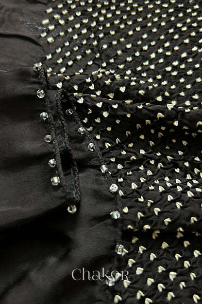 Close-up of bandhani stole featuring ombre dyeing & intricate tie dye and beads edging with 'Chakor' branding.