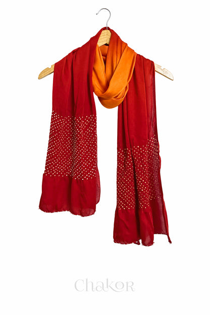 orange & red ombre bandhani  scarf with beads detailing on a hanger, brand 'Chakor' visible.
