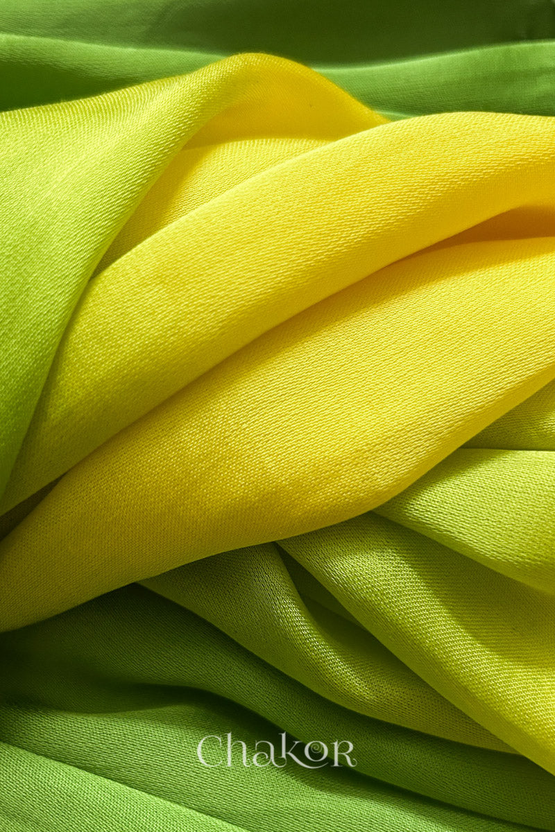 Close-up of bandhani stole featuring ombre dyeing in Yellow & green on lustrous modal fabric with 'Chakor' branding.
