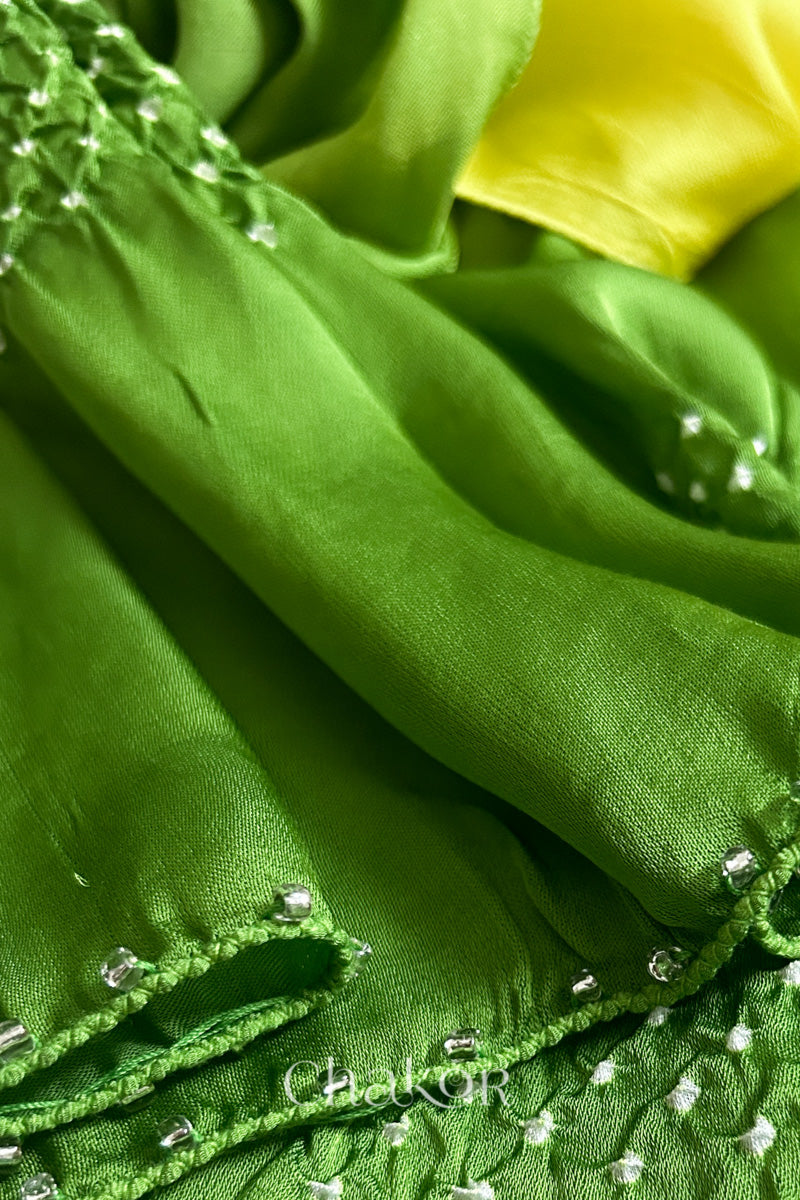 Close-up of bandhani stole featuring ombre dyeing & intricate tie dye and beads edging with 'Chakor' branding.

