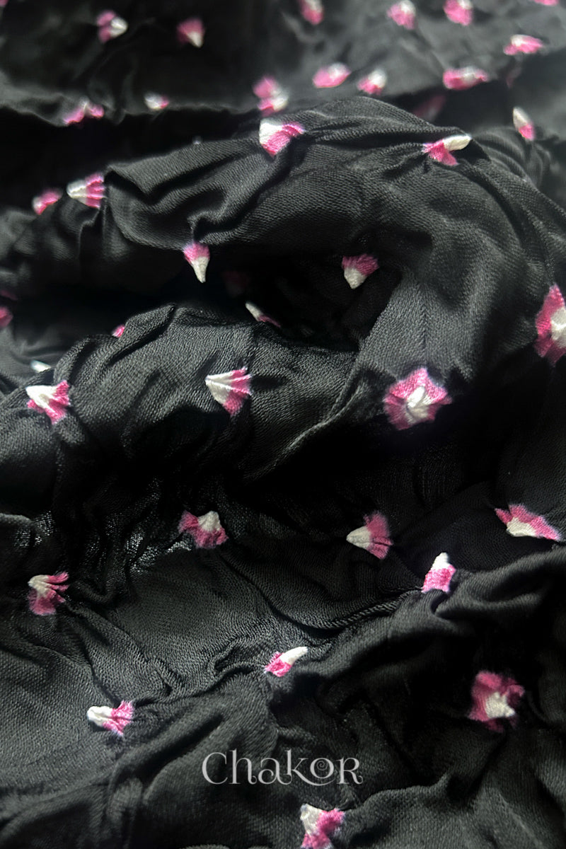 Close-up of black Bandhani modal fabric showing hand tie-dye Chakri motifs.
