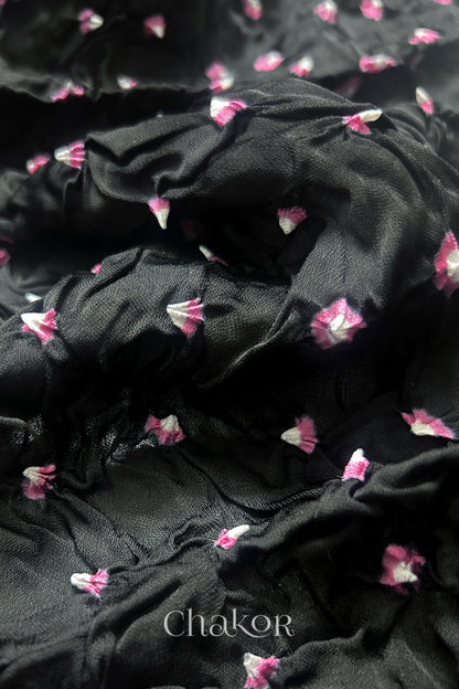 Close-up of black Bandhani modal fabric showing hand tie-dye Chakri motifs.
