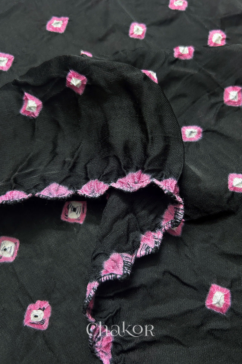 Close-up of black Bandhani modal fabric showing hand tie-dye Chakri motifs and kangri edge.
