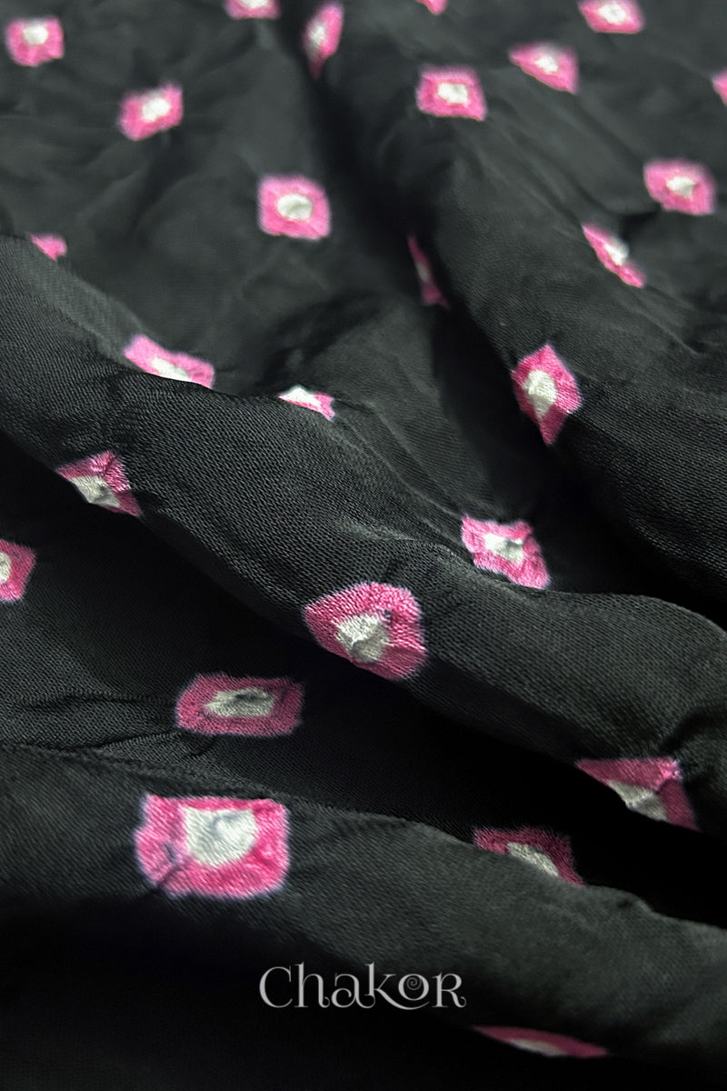 Close-up of black Bandhani modal fabric showing hand tie-dye Chakri motifs.
