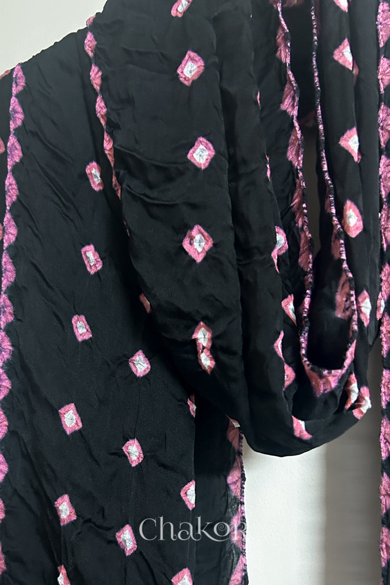 Close-up of black Bandhani modal fabric showing beautiful drape of  hand tie-dye Chakri motifs and kangri edge.
