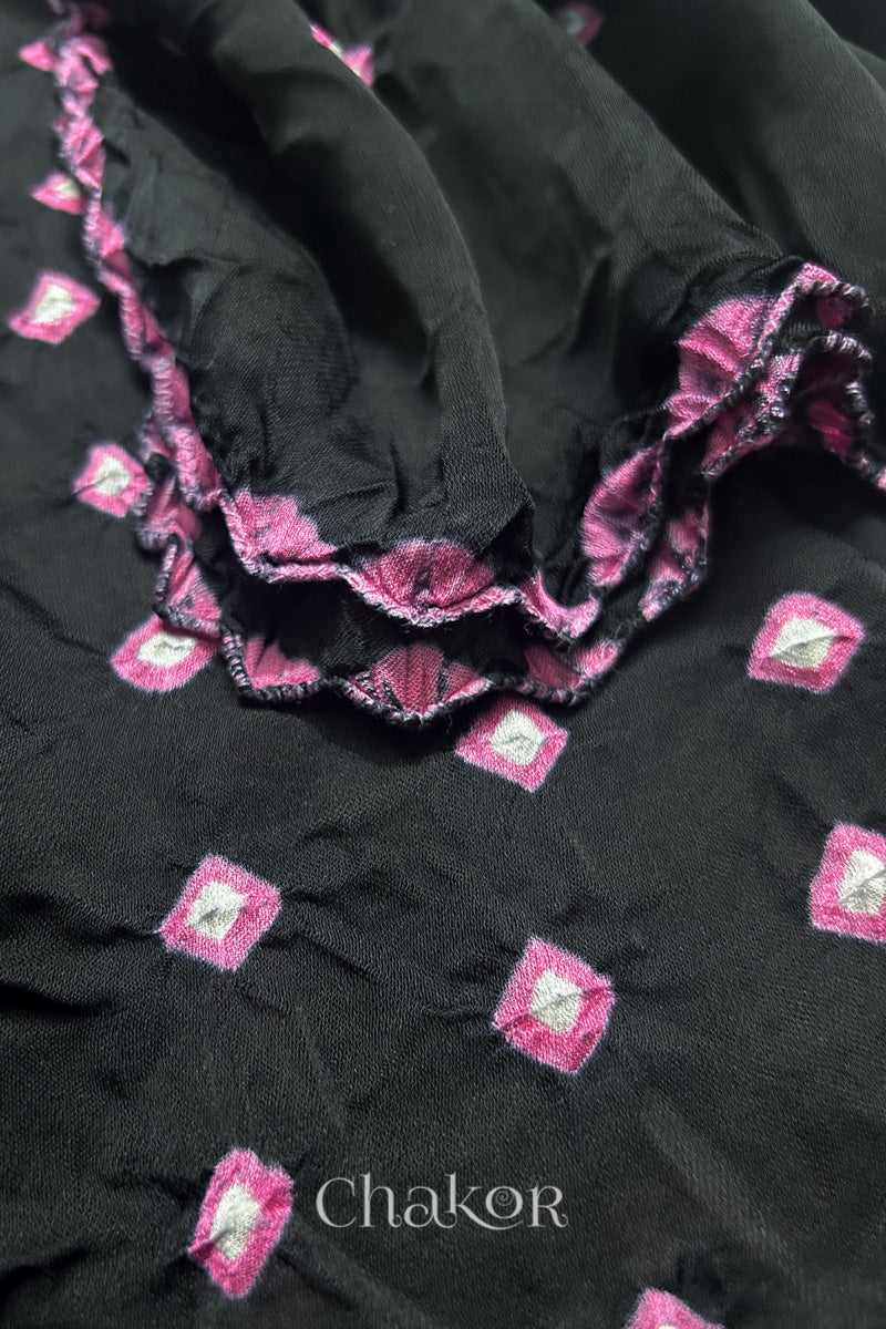 Close-up of black Bandhani modal fabric showing hand tie-dye Chakri motifs and kangri edge.
