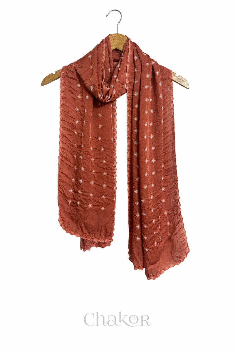 Coral Bandhani modal stole displayed on wooden hanger showing full length, drape and tie-dye layout.
