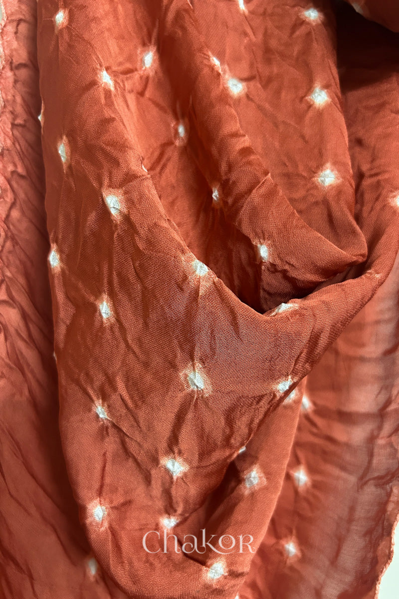 Close-up of hand tie-dye texture on coral Bandhani stole in modal fabric.
