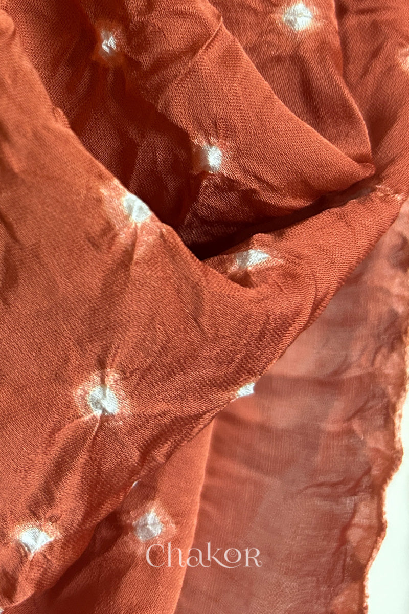 Detail view of coral Bandhani modal stole highlighting resist-dyed white dot patterns.