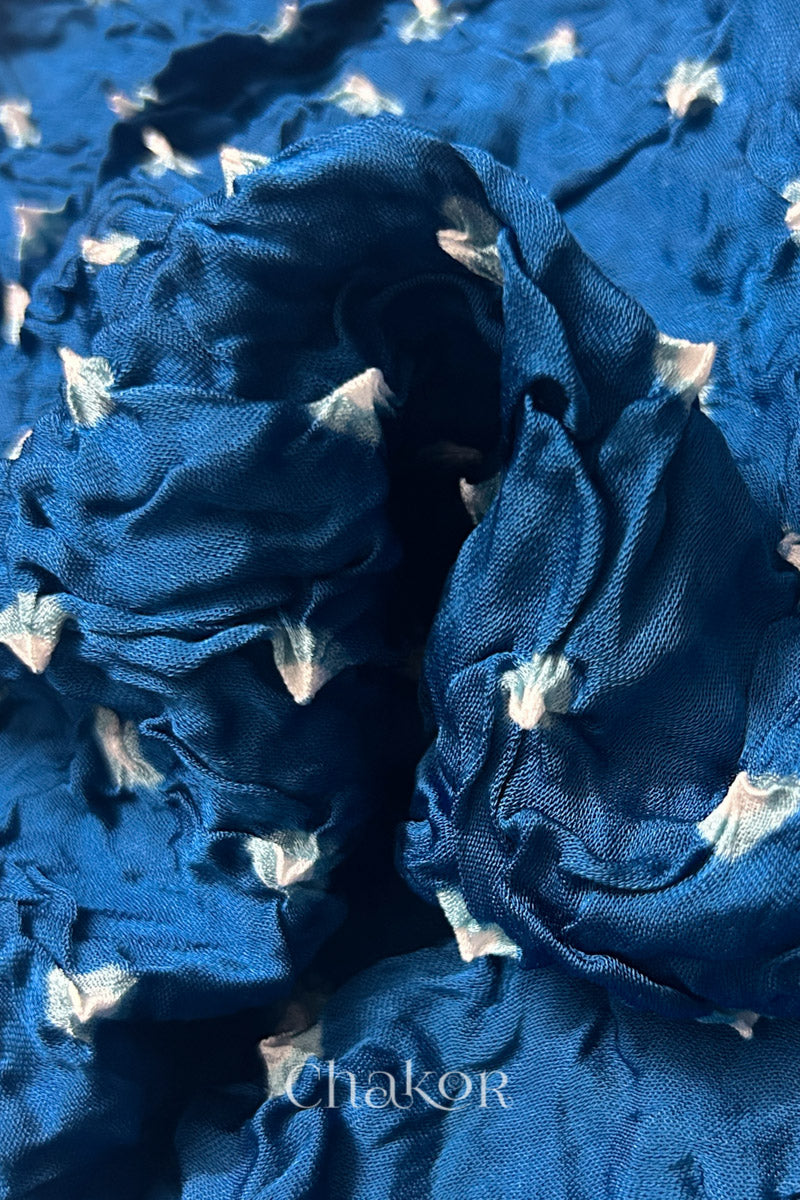 Close-up of indigo Bandhani modal fabric showing hand tie-dye Chakri motifs.
